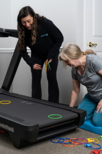 A pregnant patient working with a physical therapist on gentle mobility and breathing exercises in a bright, welcoming clinic